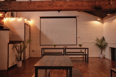brwnbox event space arranged with tables and projection screen